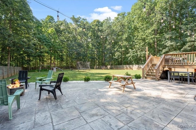 1450 Palmore Rd, Powhatan, VA 23139 - fenced backyard with a fire pit, a trampoline, a patio, stairs, and a wooden deck