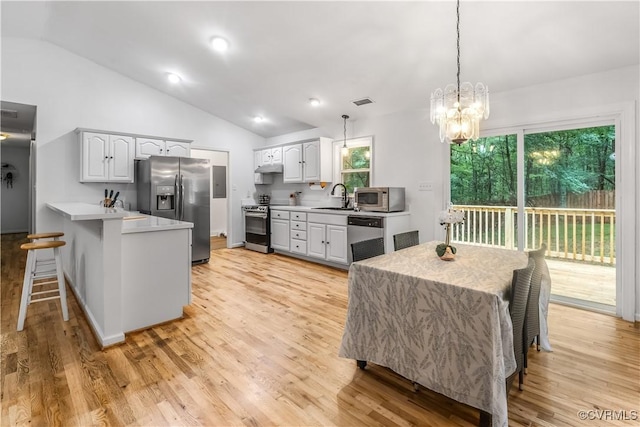 4508 Philips Path, Kents Store, VA 23084 - kitchen featuring appliances with stainless steel finishes, a peninsula, a kitchen breakfast bar, light countertops, and lofted ceiling