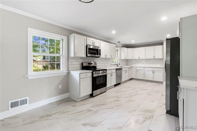 4816 Stornoway Dr, Ampthill, VA 23234 - kitchen with stainless steel appliances, ornamental molding, light countertops, tasteful backsplash, and white cabinets