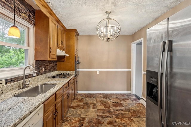 2407 Birchwood Rd, Henrico, VA 23294 - kitchen featuring stainless steel appliances, under cabinet range hood, brown cabinetry, a textured ceiling, and a chandelier