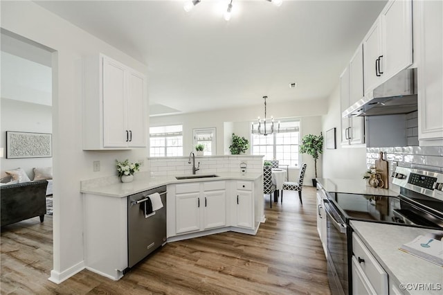 915 Jamerson Ln, Glen Allen, VA 23059 - kitchen with appliances with stainless steel finishes, under cabinet range hood, decorative backsplash, a peninsula, and a chandelier