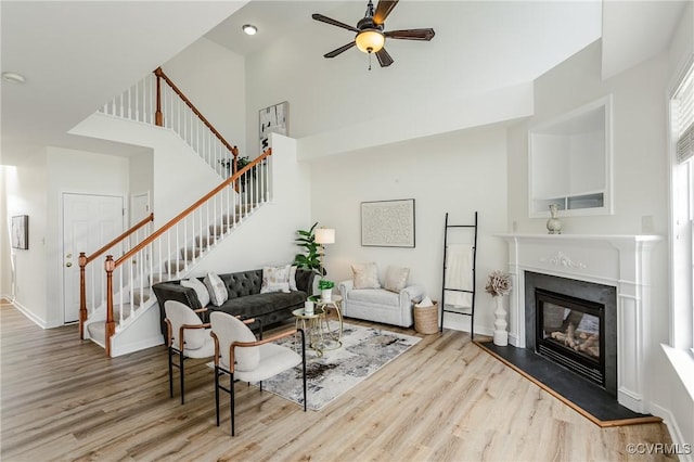 915 Jamerson Ln, Glen Allen, VA 23059 - living area with stairway, wood finished floors, a towering ceiling, a glass covered fireplace, and a ceiling fan