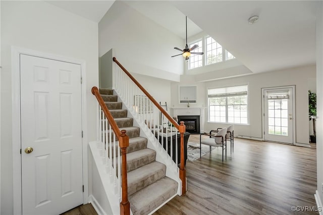 915 Jamerson Ln, Glen Allen, VA 23059 - stairway with ceiling fan, a glass covered fireplace, wood finished floors, and high vaulted ceiling