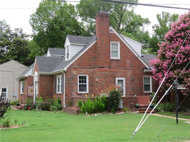 5900 River Rd, South Chesterfield, VA 23803 - back of house featuring a chimney, brick siding, and a yard