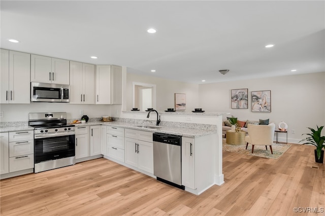 407 S 19th Ave, Hopewell, VA 23860 - kitchen featuring stainless steel appliances, a peninsula, recessed lighting, light wood-style floors, and light stone countertops