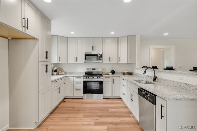 407 S 19th Ave, Hopewell, VA 23860 - kitchen with appliances with stainless steel finishes, recessed lighting, a peninsula, light stone countertops, and light wood-style flooring