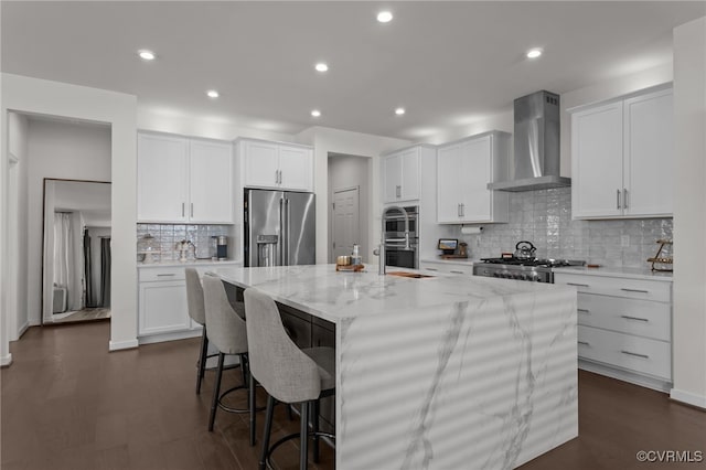 10109 Hollythorne Ln, Mechanicsville, VA 23116 - kitchen with appliances with stainless steel finishes, wall chimney exhaust hood, a center island with sink, decorative backsplash, and light stone counters