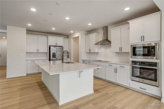 7107 Braxton Ct, Ladysmith, VA 22546 - kitchen with appliances with stainless steel finishes, wall chimney exhaust hood, light wood-type flooring, decorative backsplash, and recessed lighting