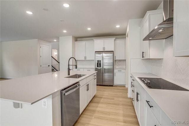 7107 Braxton Ct, Ladysmith, VA 22546 - kitchen featuring stainless steel appliances, wall chimney exhaust hood, light wood-type flooring, white cabinets, and recessed lighting