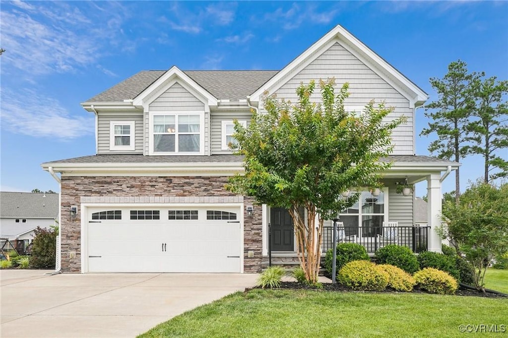 16612 Burridge Pl, Chesterfield, VA 23832 - view of front of home with driveway, an attached garage, stone siding, a front lawn, and covered porch