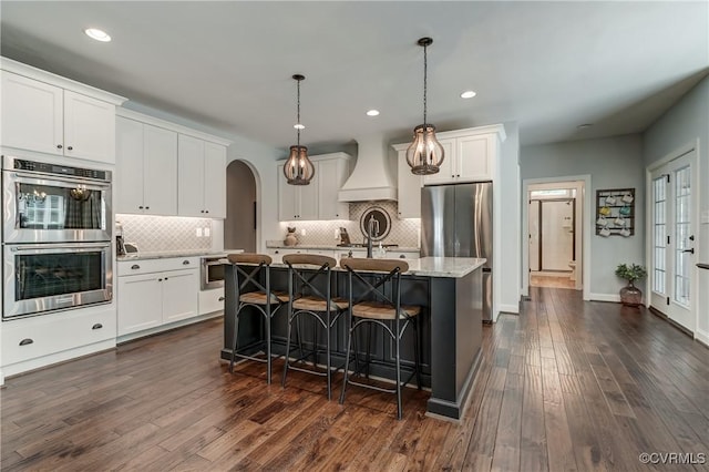 5025 Ellis Meadows Ct, Glen Allen, VA 23059 - kitchen featuring stainless steel appliances, custom range hood, arched walkways, backsplash, and recessed lighting