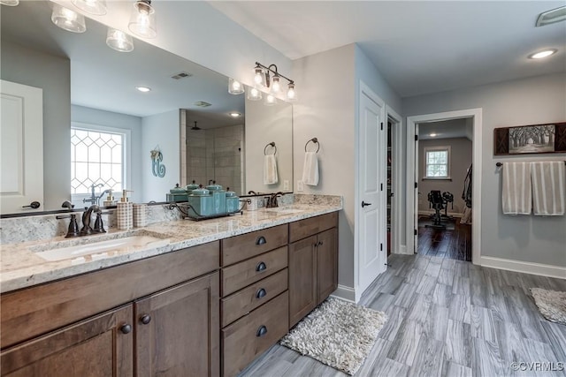 5025 Ellis Meadows Ct, Glen Allen, VA 23059 - bathroom with double vanity, a tile shower, wood finished floors, and recessed lighting