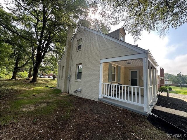 1883 Fairfax St, Petersburg, VA 23805 - view of side of home with a porch, brick siding, and a chimney