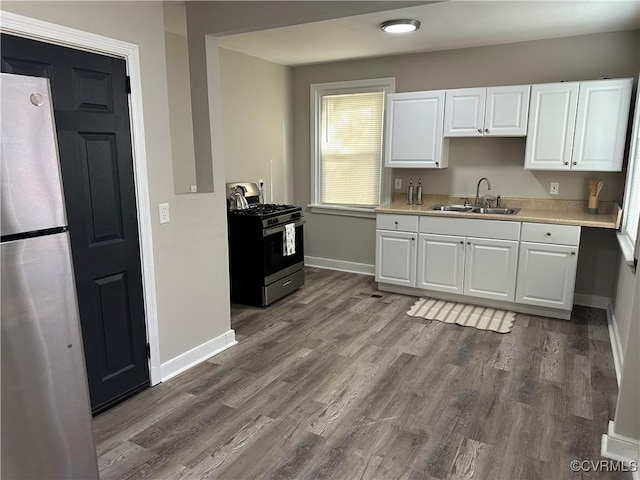 1883 Fairfax St, Petersburg, VA 23805 - kitchen featuring appliances with stainless steel finishes, light countertops, white cabinets, and wood finished floors