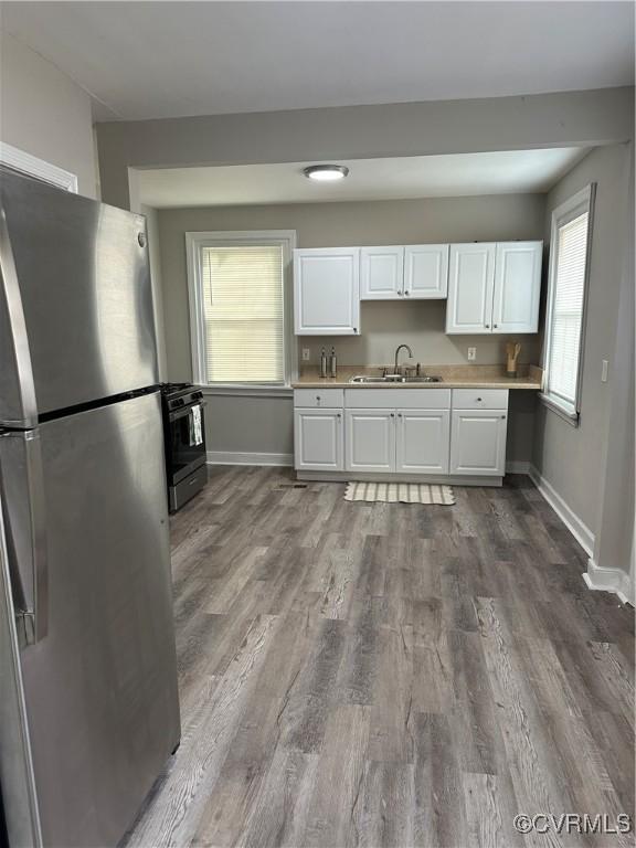 1883 Fairfax St, Petersburg, VA 23805 - kitchen featuring freestanding refrigerator, stove, white cabinets, light countertops, and dark wood-style floors