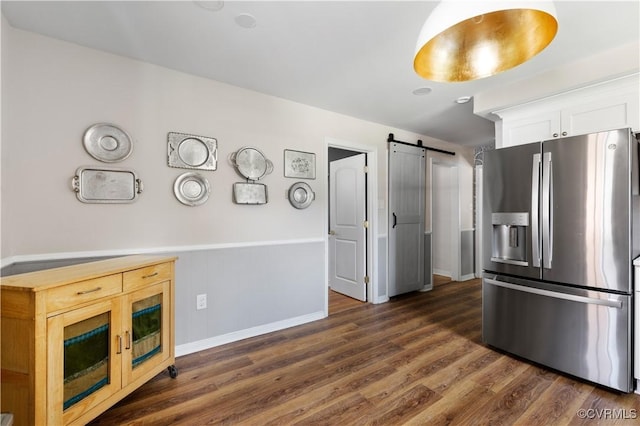 6213 Monument Ave, Richmond, VA 23226 - kitchen with stainless steel fridge, a barn door, dark wood-type flooring, and white cabinetry