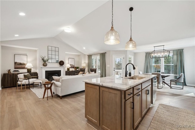 LOT47 Wendenburg Cir Lot 47, King William, VA 23009 - kitchen featuring light wood-style floors, light stone counters, a glass covered fireplace, hanging light fixtures, and vaulted ceiling