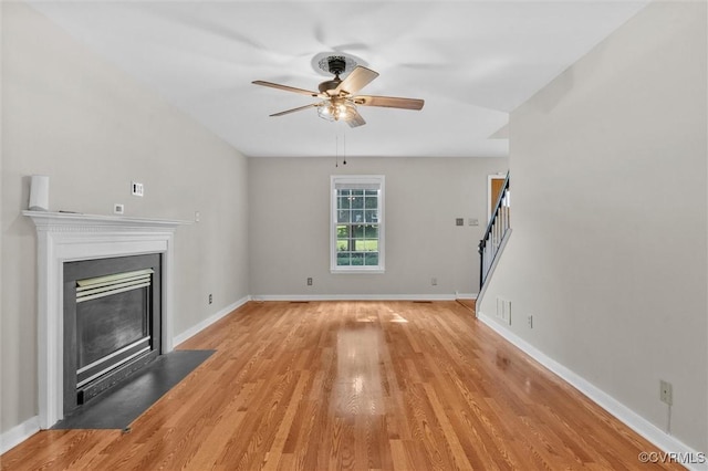 7906 Belmont Stakes Dr, Midlothian, VA 23112 - unfurnished living room with ceiling fan, a fireplace with flush hearth, stairway, and light wood-style flooring