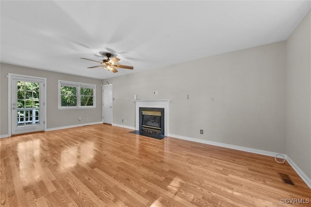 7906 Belmont Stakes Dr, Midlothian, VA 23112 - unfurnished living room with light wood-type flooring, ceiling fan, and a fireplace with flush hearth