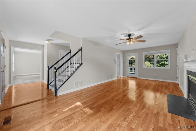 7906 Belmont Stakes Dr, Midlothian, VA 23112 - unfurnished living room with stairway, a fireplace with flush hearth, ceiling fan, and light wood-style floors