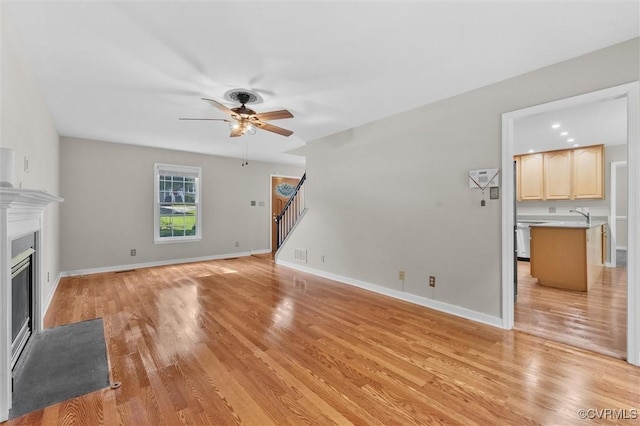 7906 Belmont Stakes Dr, Midlothian, VA 23112 - unfurnished living room featuring a ceiling fan, stairs, a fireplace with flush hearth, and light wood-type flooring