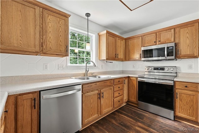 11918 Hazelnut Branch Ter, Midlothian, VA 23112 - kitchen featuring appliances with stainless steel finishes, dark wood-type flooring, hanging light fixtures, brown cabinets, and light countertops