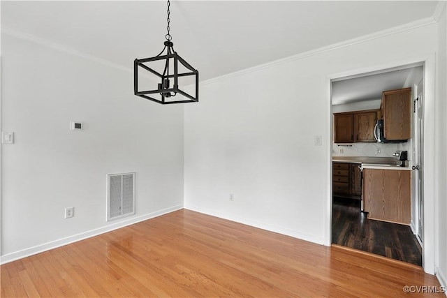 11918 Hazelnut Branch Ter, Midlothian, VA 23112 - unfurnished dining area featuring a chandelier, light wood finished floors, and ornamental molding