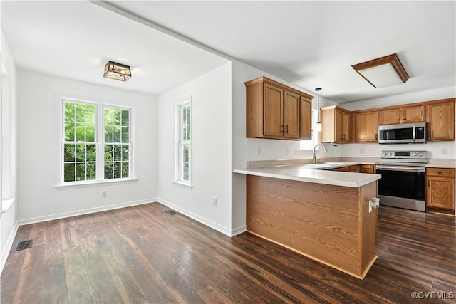 11918 Hazelnut Branch Ter, Midlothian, VA 23112 - kitchen with stainless steel appliances, brown cabinetry, light countertops, and dark wood finished floors