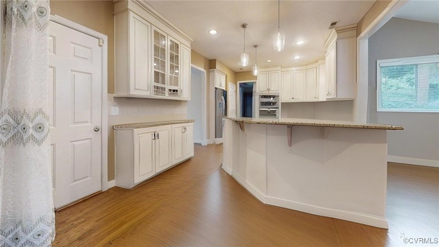 2024 Rockstone Pl, Henrico, VA 23238 - kitchen with appliances with stainless steel finishes, recessed lighting, light wood-style flooring, glass insert cabinets, and a breakfast bar area