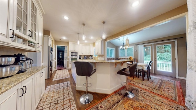 2024 Rockstone Pl, Henrico, VA 23238 - kitchen featuring stainless steel appliances, light wood-style floors, a kitchen bar, light stone counters, and recessed lighting