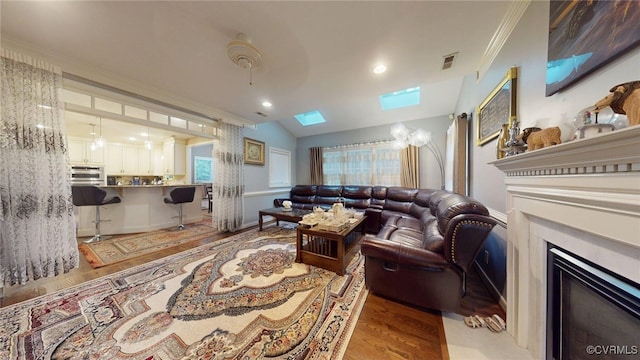 2024 Rockstone Pl, Henrico, VA 23238 - living area featuring a fireplace with flush hearth, light wood finished floors, a skylight, crown molding, and lofted ceiling