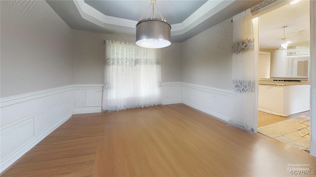 2024 Rockstone Pl, Henrico, VA 23238 - unfurnished dining area featuring a wainscoted wall, a tray ceiling, a decorative wall, and wood finished floors