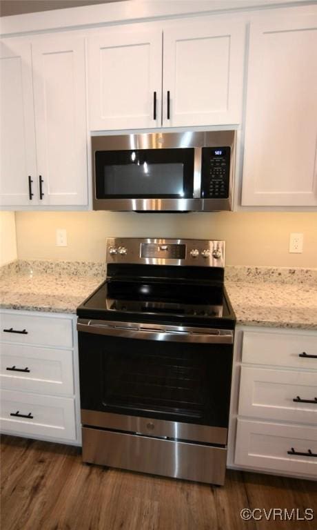 5102 Front Dr, North Dinwiddie, VA 23803 - kitchen featuring stainless steel appliances, dark wood finished floors, white cabinets, and light stone countertops