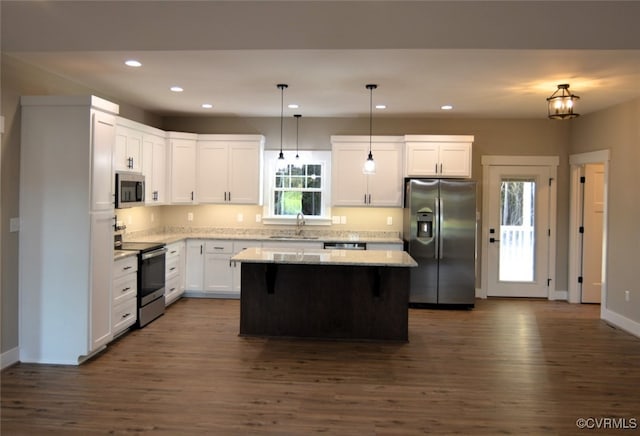 5102 Front Dr, North Dinwiddie, VA 23803 - kitchen with appliances with stainless steel finishes, a kitchen island, recessed lighting, dark wood-style floors, and light stone countertops