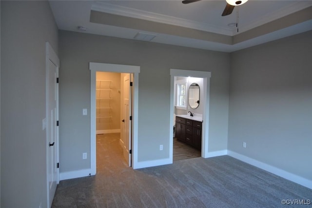 5102 Front Dr, North Dinwiddie, VA 23803 - unfurnished bedroom featuring a tray ceiling, a walk in closet, dark carpet, ornamental molding, and ensuite bathroom