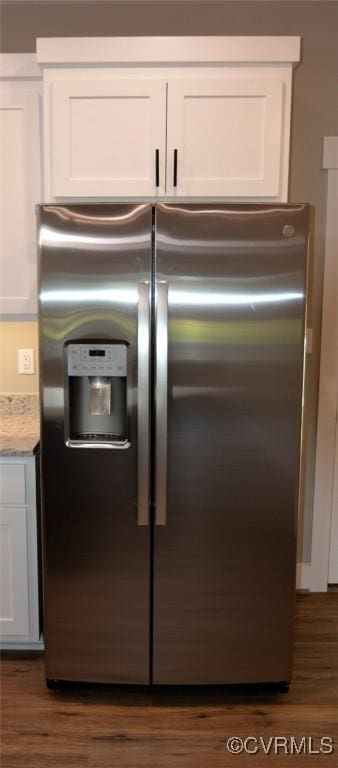 5102 Front Dr, North Dinwiddie, VA 23803 - detailed view of stainless steel refrigerator with ice dispenser, white cabinets, dark wood-type flooring, and light stone countertops