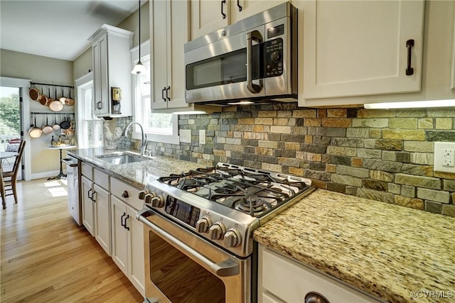 7413 Settlers Ridge Ct, Henrico, VA 23231 - kitchen with appliances with stainless steel finishes, light stone countertops, decorative backsplash, light wood finished floors, and pendant lighting