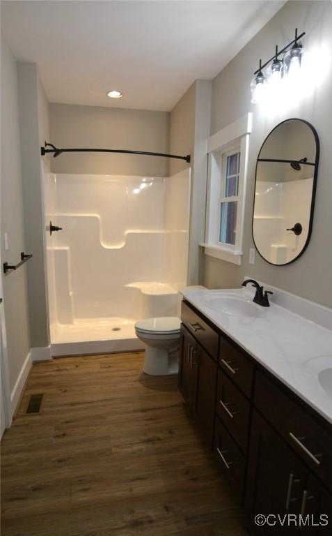 5104 Front Dr, North Dinwiddie, VA 23803 - full bathroom with wood finished floors, double vanity, a shower, and recessed lighting