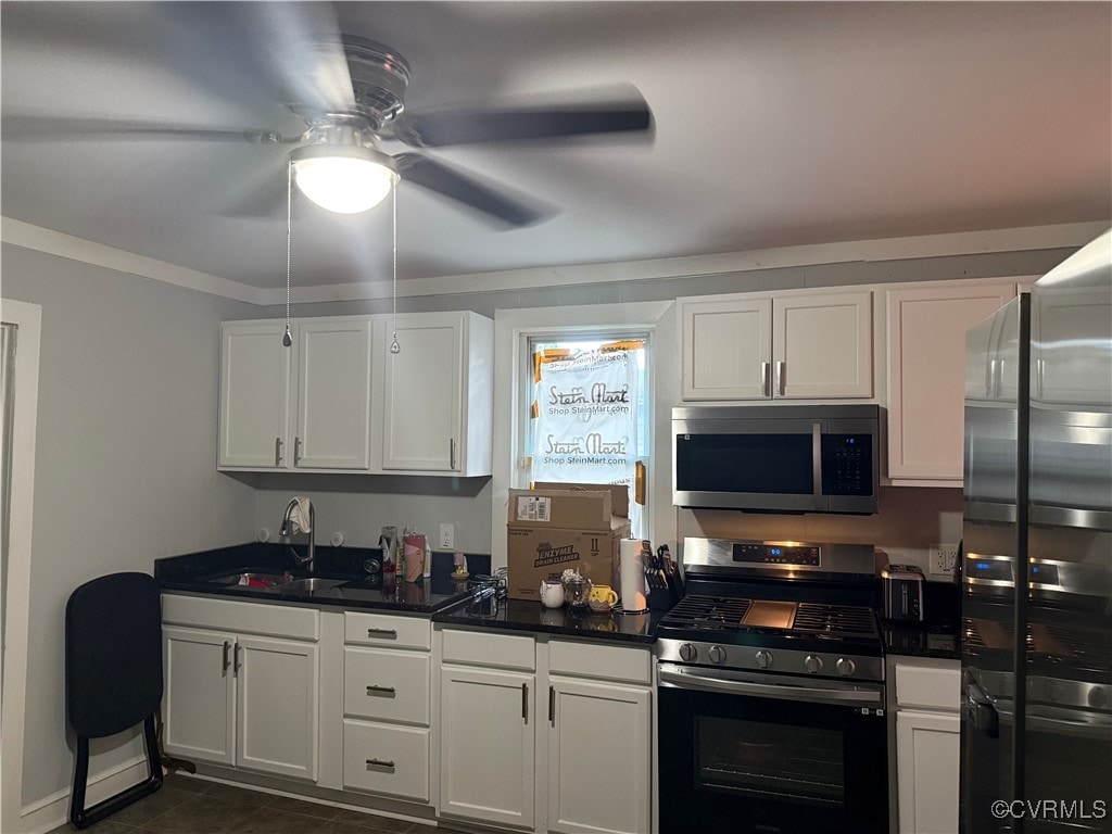 662 Wise Ave, Richmond, VA 23803 - kitchen with stainless steel appliances, a ceiling fan, dark countertops, white cabinetry, and crown molding