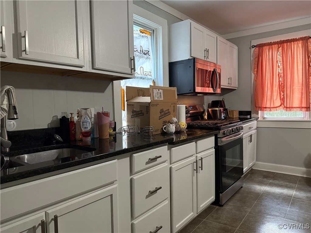 662 Wise Ave, Richmond, VA 23803 - kitchen featuring appliances with stainless steel finishes, dark tile patterned flooring, dark countertops, and white cabinetry