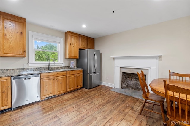3167 Trenholm Rd, Powhatan, VA 23139 - kitchen featuring stainless steel appliances, light wood-style flooring, light stone counters, a fireplace with flush hearth, and recessed lighting