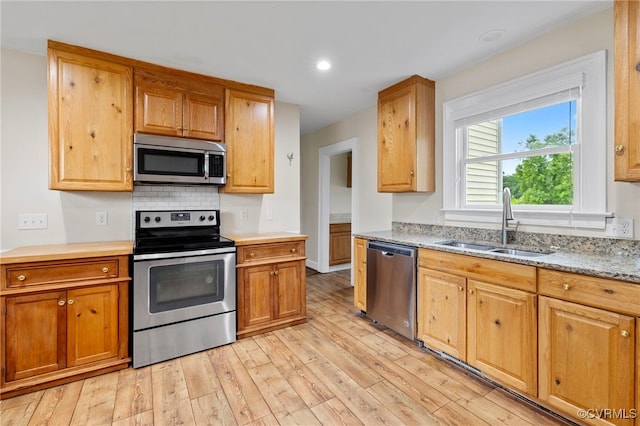 3167 Trenholm Rd, Powhatan, VA 23139 - kitchen with appliances with stainless steel finishes, light wood finished floors, backsplash, light stone counters, and recessed lighting