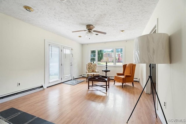 1415 New Market Rd 1411, Henrico, VA 23231 - living area with baseboard heating, a baseboard radiator, light wood-style flooring, ceiling fan, and a textured ceiling