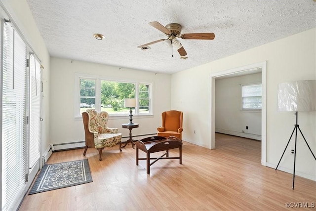 1415 New Market Rd 1411, Henrico, VA 23231 - living area featuring a textured ceiling, light wood-style flooring, a baseboard radiator, a ceiling fan, and a baseboard heating unit