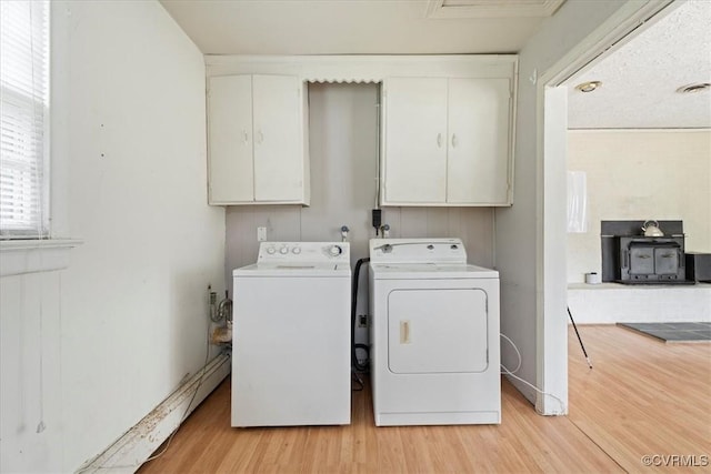 1415 New Market Rd 1411, Henrico, VA 23231 - laundry area with separate washer and dryer, cabinet space, a wood stove, light wood finished floors, and baseboard heating