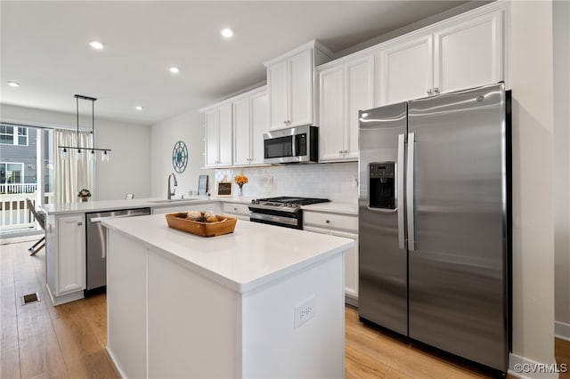 1665 Ewing Park Loop, Midlothian, VA 23113 - kitchen with appliances with stainless steel finishes, a peninsula, decorative backsplash, white cabinets, and recessed lighting