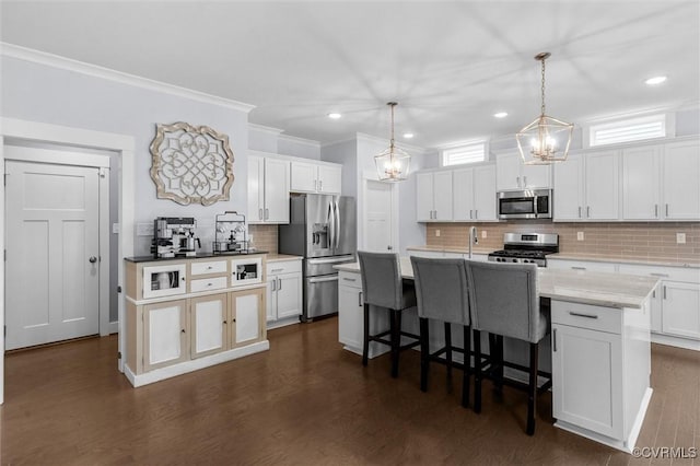 18007 Twin Falls Ln, Moseley, VA 23120 - kitchen featuring crown molding, stainless steel appliances, tasteful backsplash, a kitchen breakfast bar, and white cabinets