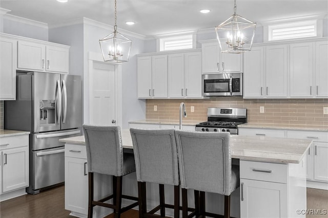 18007 Twin Falls Ln, Moseley, VA 23120 - kitchen featuring a chandelier, appliances with stainless steel finishes, a center island with sink, white cabinets, and ornamental molding