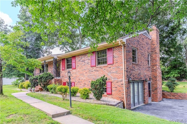 1020 Challis Ln, Sandston, VA 23150 - view of front of home with a front lawn, brick siding, a chimney, and a patio