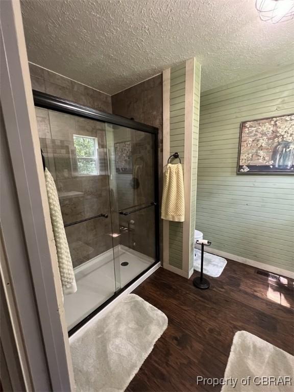 102 Mechams Cove Rd, Topping, VA 23169 - full bath with a shower stall, wood finished floors, and a textured ceiling